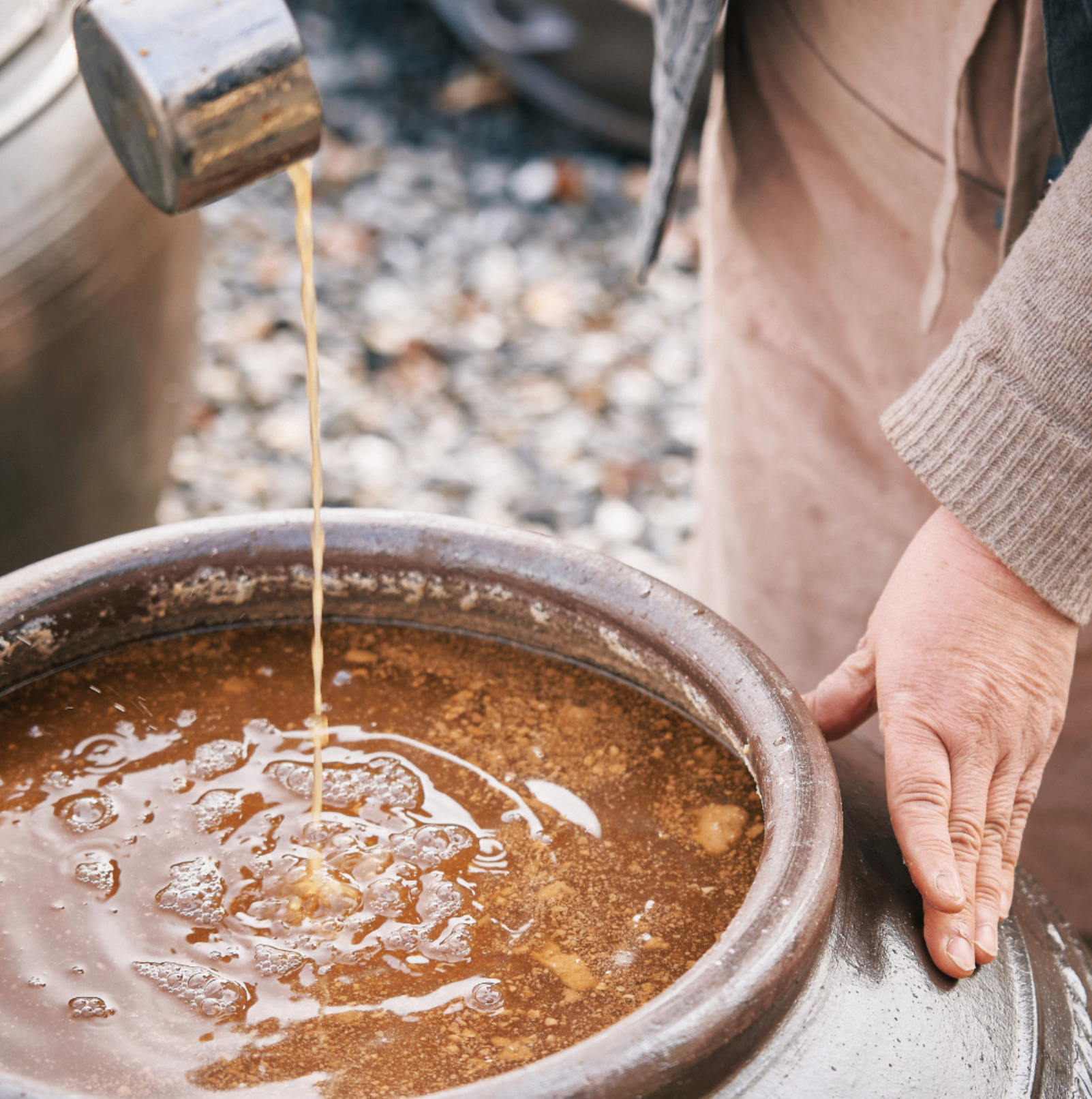 Ladling fermented jang from an earthenware crock
