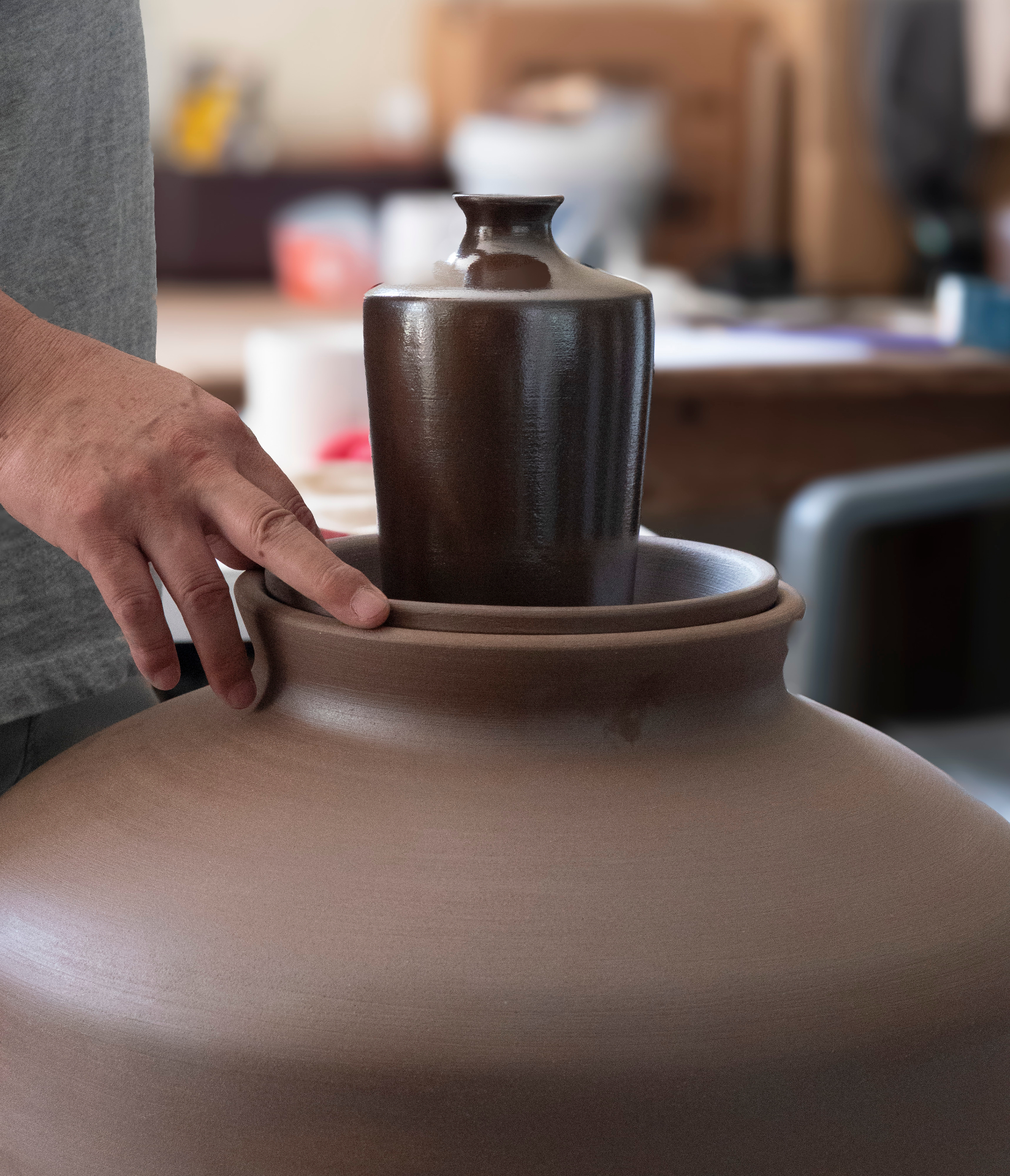 Artisan hands carefully crafting traditional Korean ceramic hangari pottery vessel for fermentation