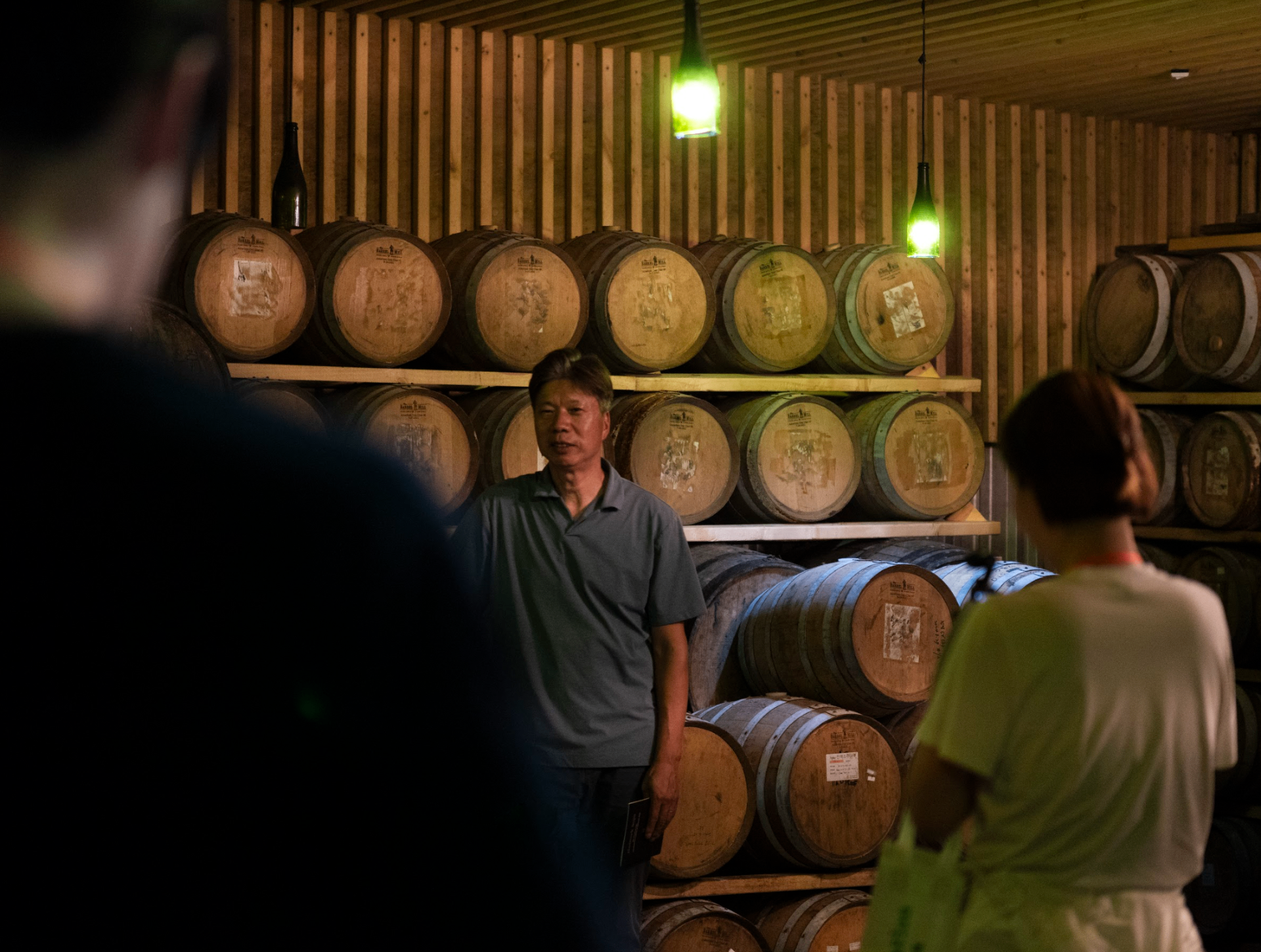 Master artisan explaining traditional soju aging in wooden barrels